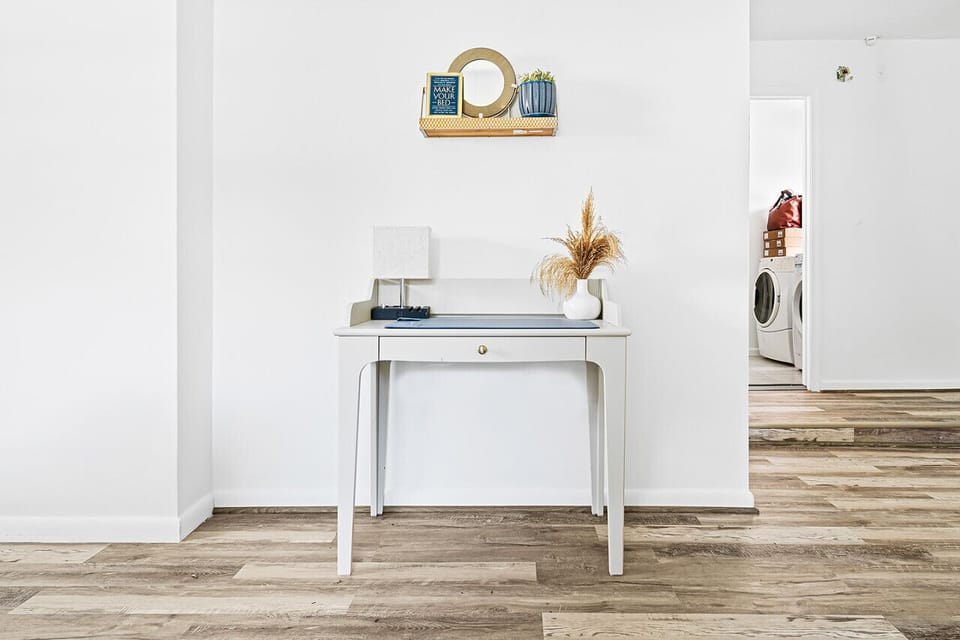 A clean and bright space, possibly a hallway or entryway, with a simple yet stylish table and decor.

