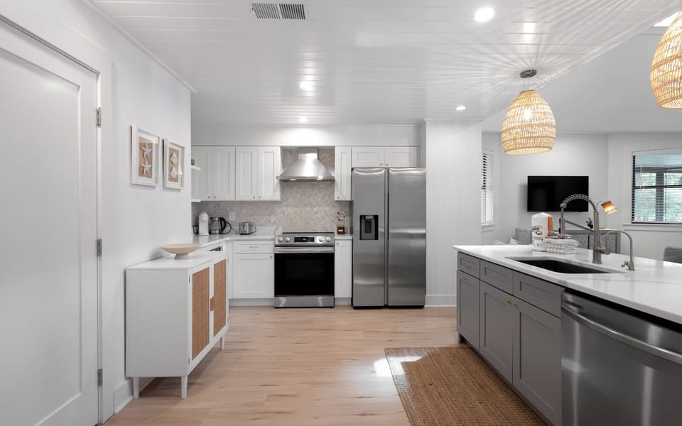 Cook gourmet meals in this bright, modern kitchen featuring stainless steel appliances, quartz countertops, and stylish pendant lighting that creates the perfect culinary atmosphere.