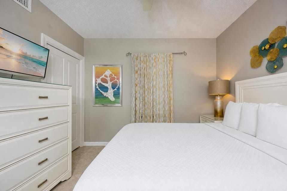 A guest suite with a queen bed offers restful comfort and coastal-inspired art to calm your spirit at day's end