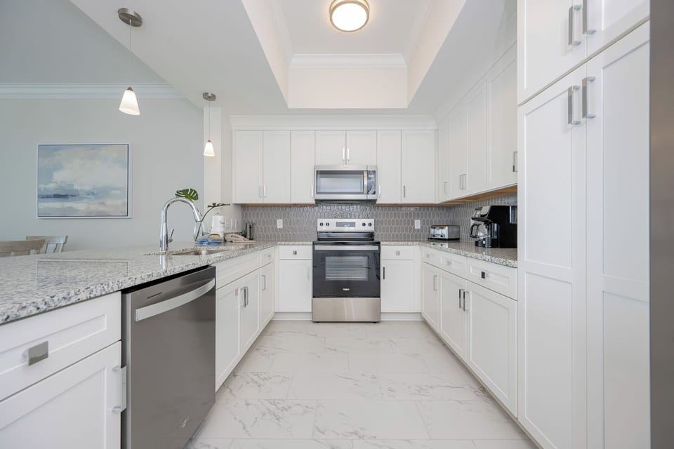 Prepare meals in this stylish kitchen featuring sleek cabinetry, granite countertops, and stainless appliances