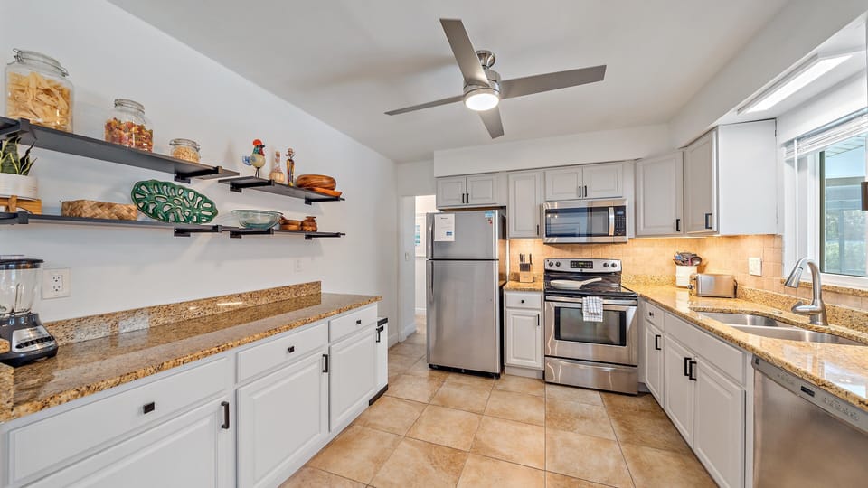 The beautifully updated kitchen provides ample granite counter space, stainless steel appliances, and sleek shelving to make cooking during your Sarasota vacation a breeze.