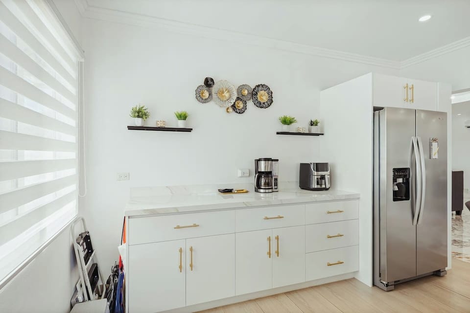 Another side of kitchen that features, refrigerator, a handy coffee maker, and a toaster.