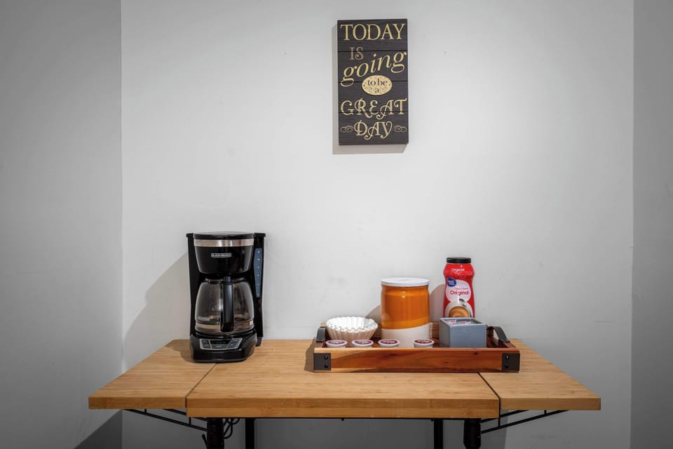 Kickstart your day with our cheerful coffee station, complete with a drip brewer, filters, creamers, and an uplifting message to greet your morning.