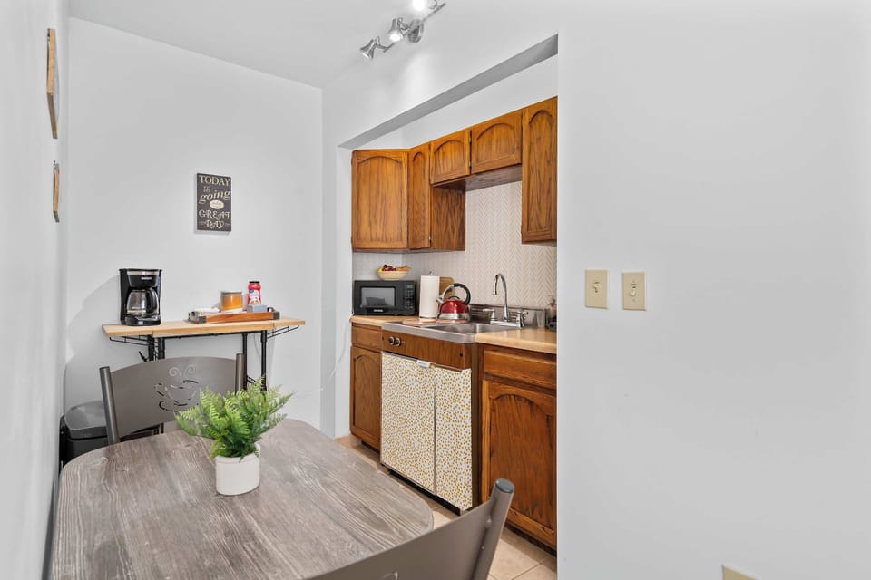 Compact and cheerful kitchen-dining area featuring a kitchenette, coffee station, and cozy table for two, everything you need for a comfortable and convenient stay.