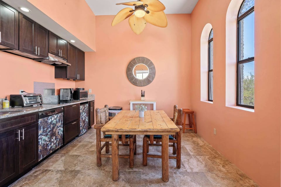 Gather around the rustic dining table under soaring ceilings and soft natural light - perfect for meals, board games, or planning your next desert adventure.