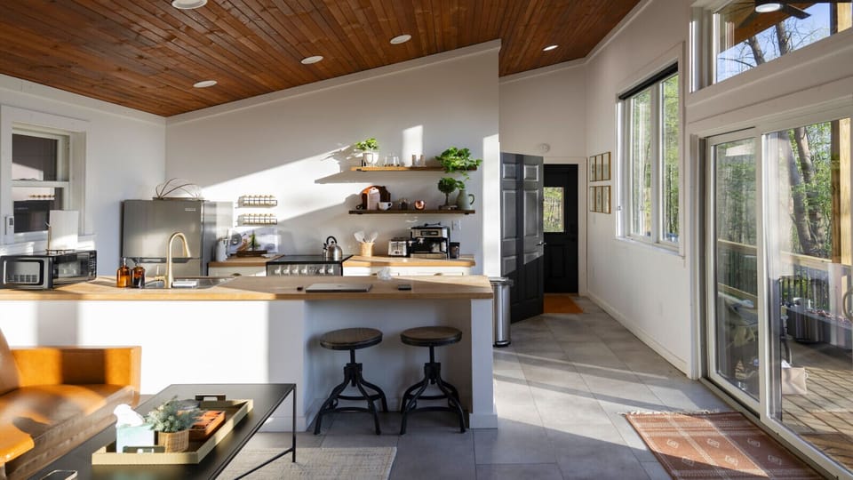 The main living space in this studio cabin is massive and features a leather sofa and smart TV