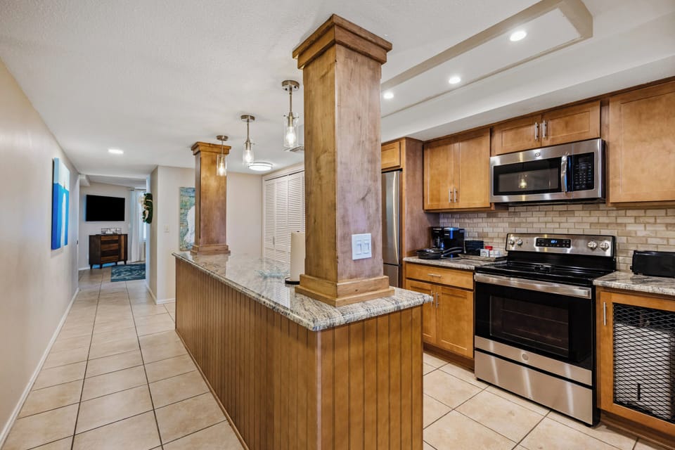 The kitchen features stainless appliances and Keurig and drip coffeemakers.