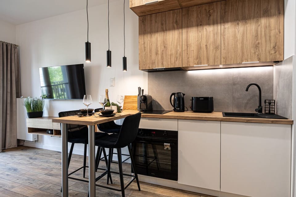 Modern kitchen with a dining area and cooking facilities, perfect for longer stays near Bydgoszcz’s Old Town and charming local restaurants.