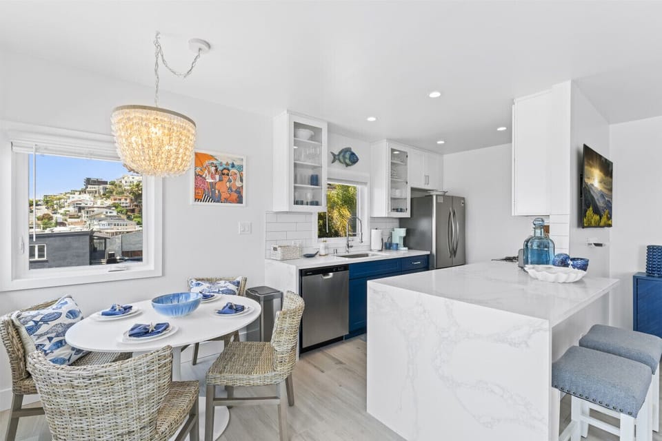 Modern kitchen with a sleek island, ocean views, and chic dining area.