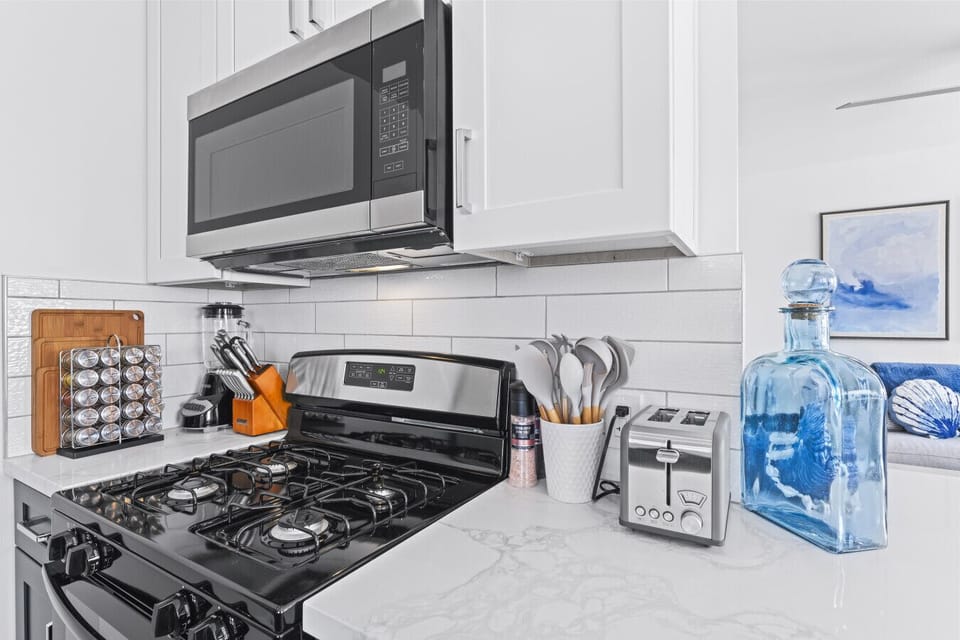 Fully equipped kitchen with stylish countertops and essential appliances.