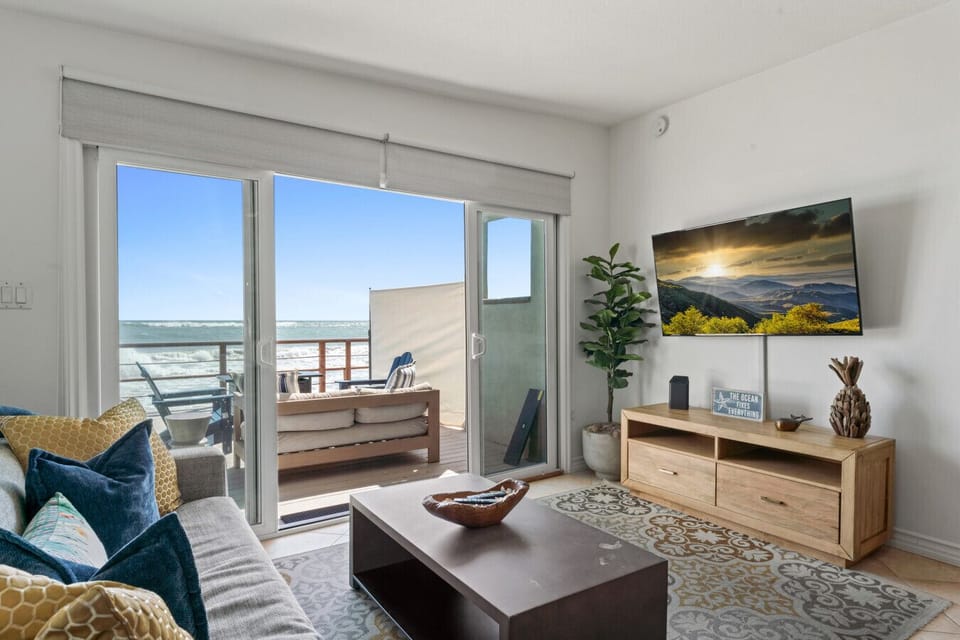 Bright, cozy living room with direct ocean views and a smart TV.