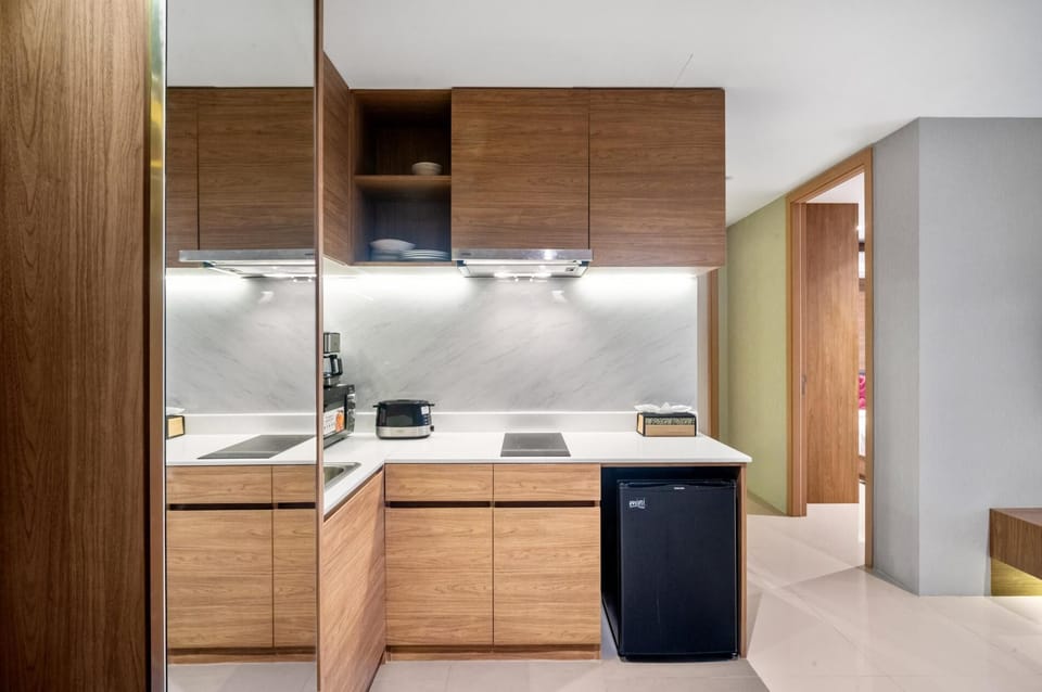 Modern kitchenette with stylish wood cabinetry, electric hob and essential appliances.