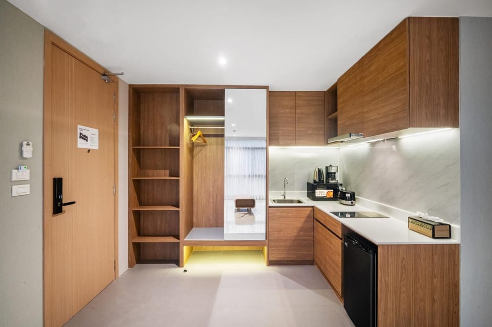 Modern kitchenette with stylish wood cabinetry, electric hob and essential appliances.