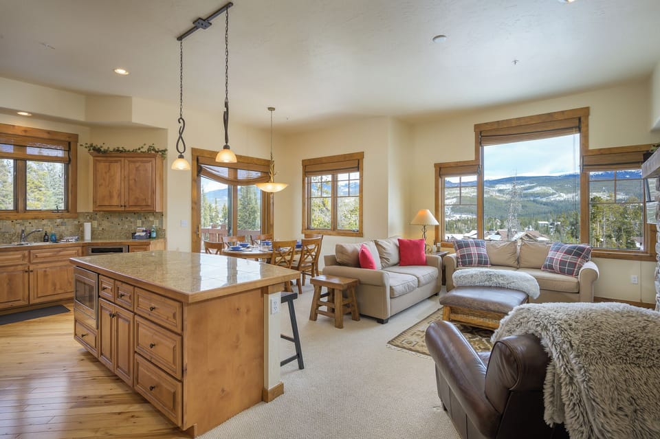 - Open concept living area blends kitchen dining and lounge with mountain views   - Plush seating and warm décor create a welcoming space for families and friends   - Large windows brighten the room with natural light and scenic backdrops