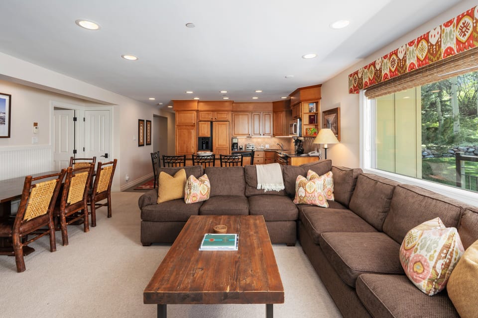 Open living space featuring oversized sectional, live-edge coffee table, and gourmet kitchen. Dining for 6 and large windows with mountain views make this perfect for groups.