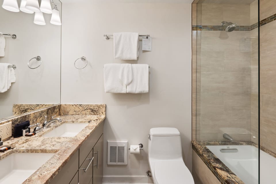 Double vanity and a tub shower finished with beautiful tile.