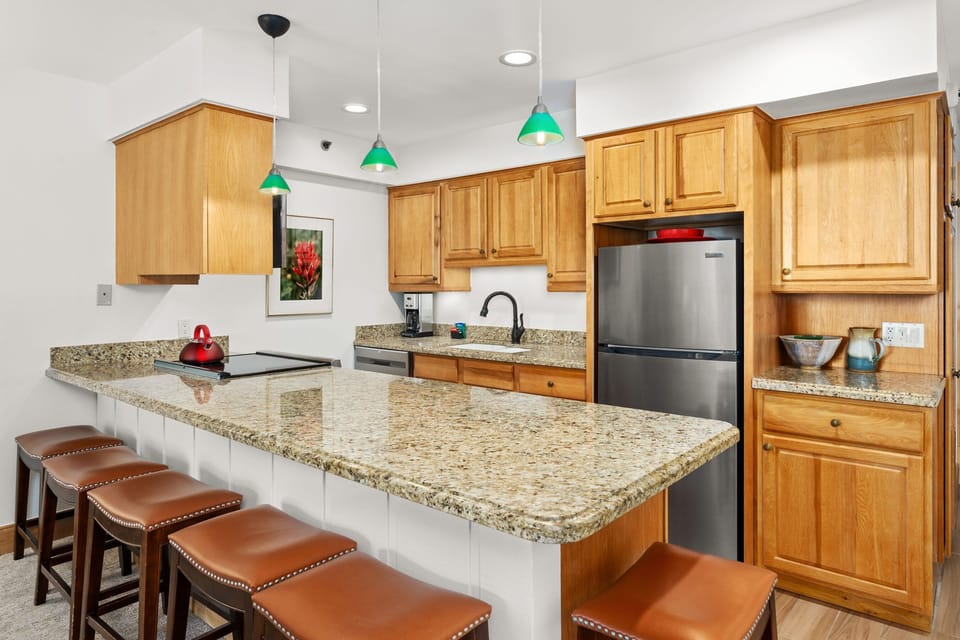Spacious kitchen with granite countertops and large center island with bar seating for 6. Fully stocked with full size appliances and everything guests need for comfortable meal preparation.