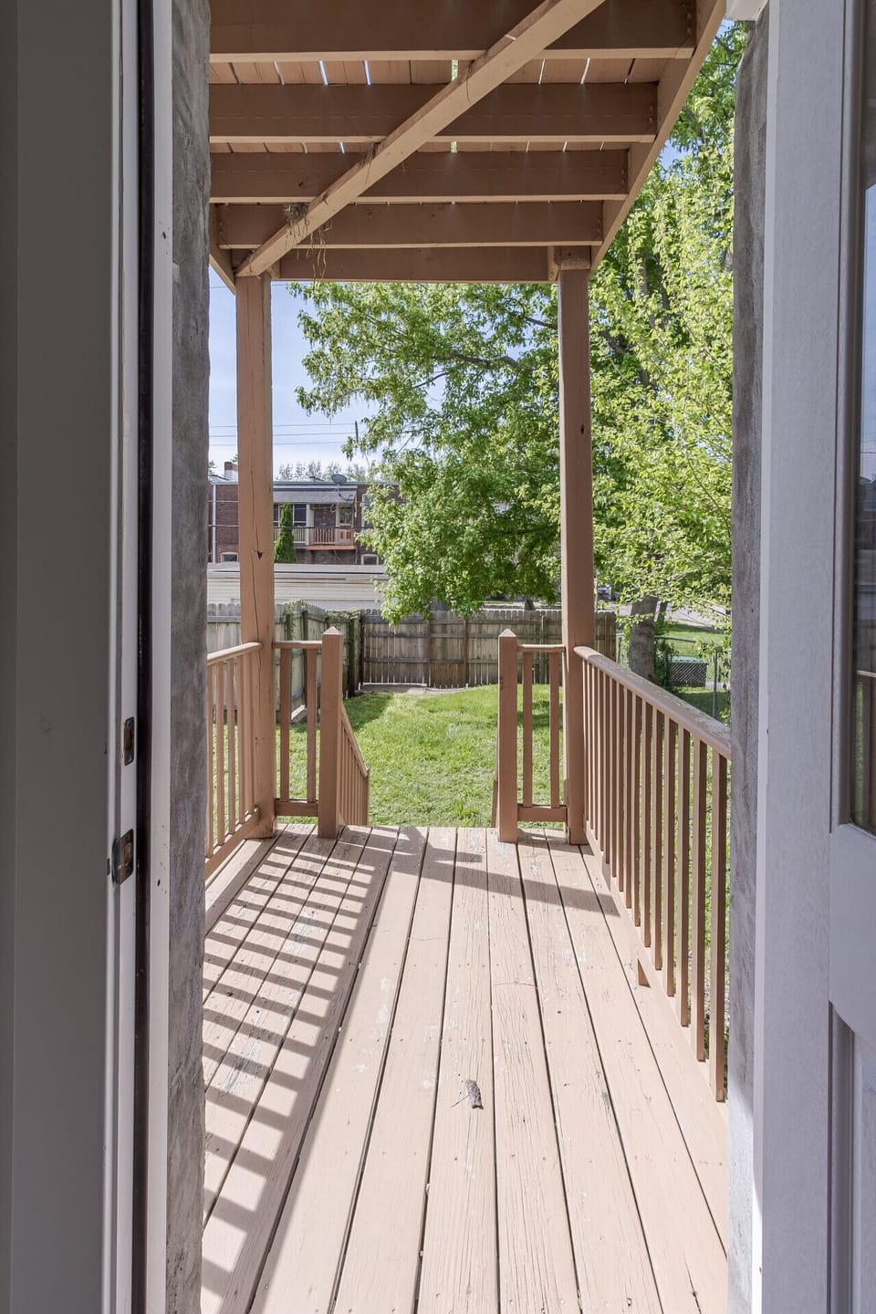 Back Deck & Fenced Backyard: Step outside to enjoy fresh air on this private raised back deck overlooking a lush green grassy yard and fully fenced perimeter. Featuring sturdy wooden railings and direct door access from the main living area, this outdoor 