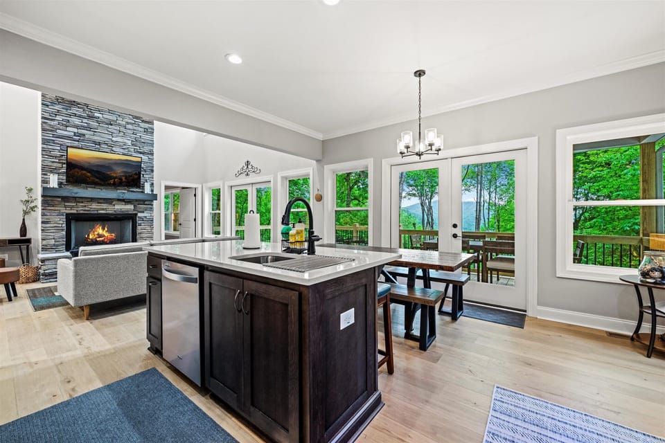 Open-concept kitchen with deck access and cozy fireplace views