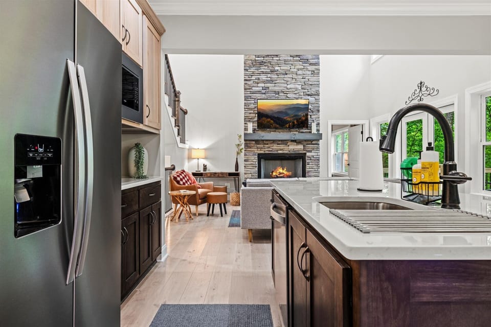 Kitchen island overlooks the living room with fireplace and tall ceilings