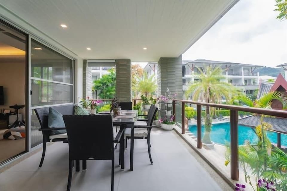Private balcony with outdoor seating overlooking the pool