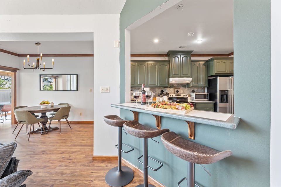 Enjoy casual mornings or evening snacks at this inviting kitchen bar, complete with comfy stools, elegant finishes, and a fresh charcuterie board ready to welcome you home