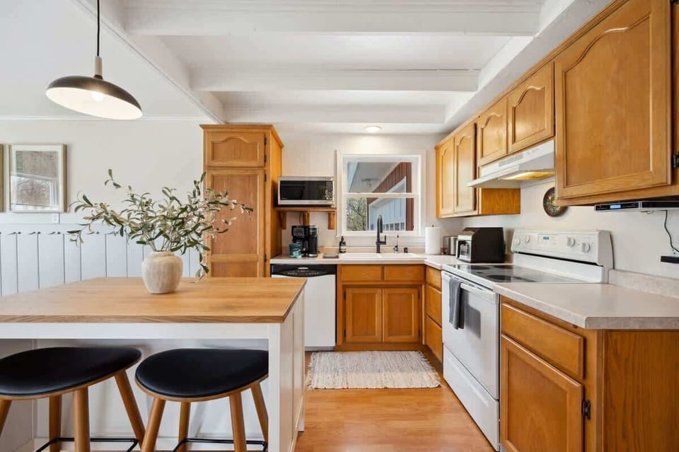 A sunny, fully equipped kitchen, featuring both a standard coffee maker and Keurig, dishwasher, microwave, toaster, and more-perfect for everything from morning pancakes to holiday dinners.