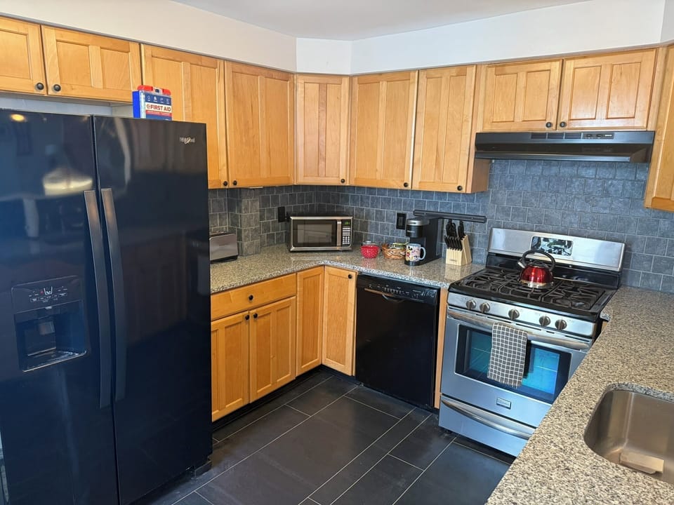 Spacious open design kitchen, fully equipped with large refrigerator, oven / stove combo, and dishwasher.
