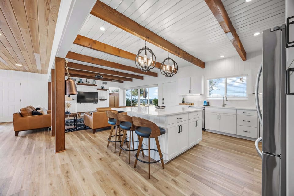 Open kitchen and living area with exposed wood beams and natural light