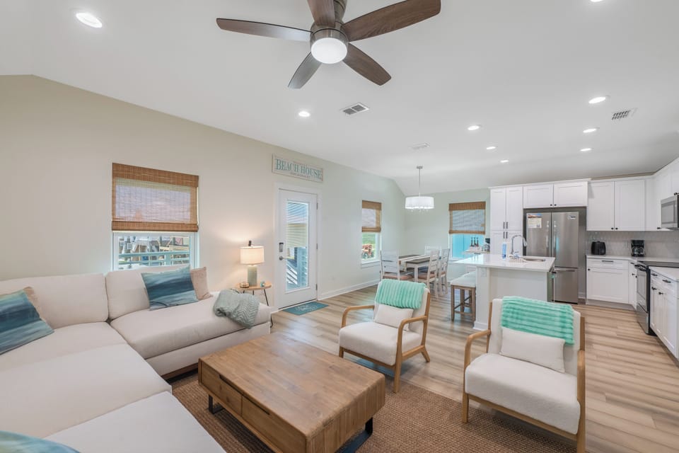 Relax in your bright, coastal-inspired living space with comfortable seating, modern kitchen, and peaceful beach house vibes throughout.