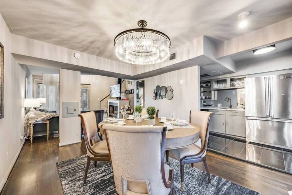 Open dining area with seating for four, featuring a beautiful chandelier.