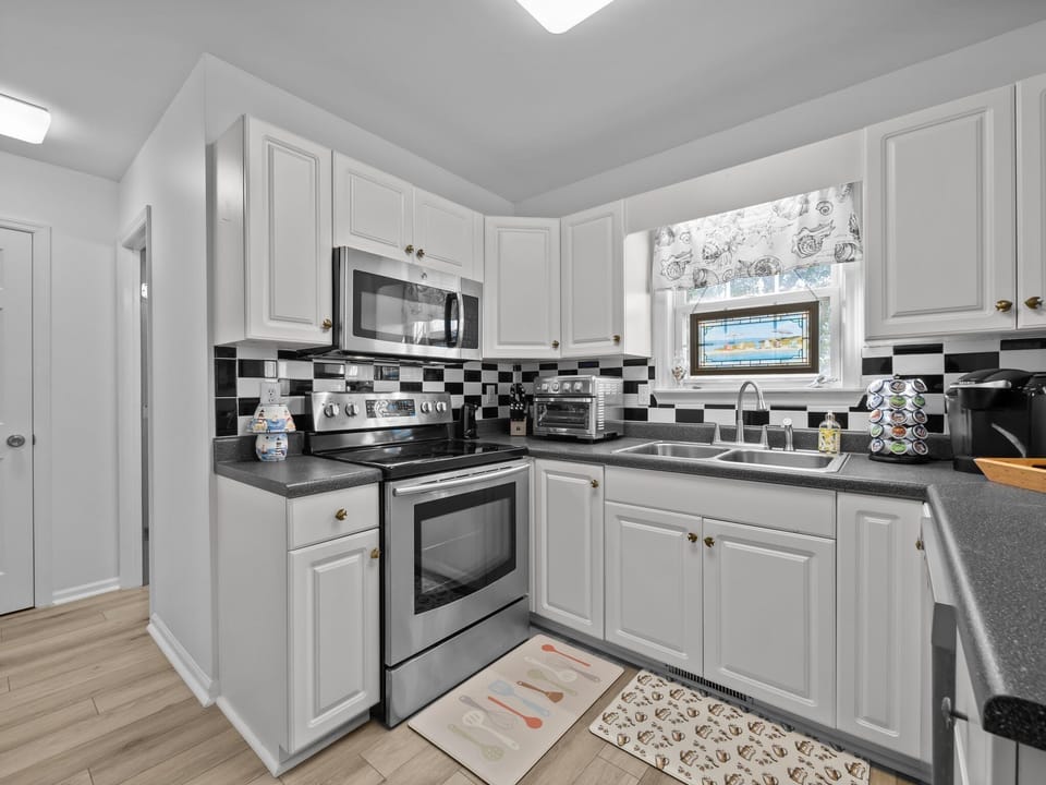 Your fully equipped kitchen features stainless steel appliances and stylish checkered backsplash for cooking memorable meals together.