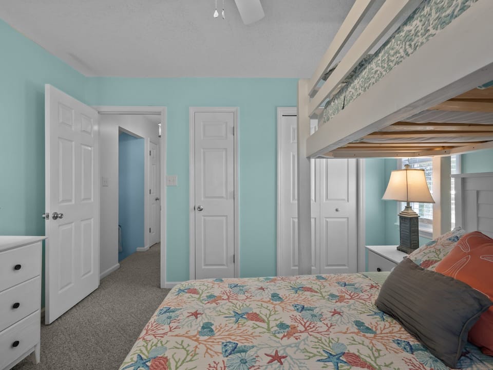 Rest peacefully in your charming bunk room, featuring ocean-themed bedding and cheerful coastal colors that create a cozy retreat.