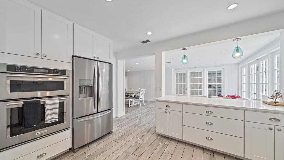 The chef's dream kitchen boasts top-of-the-line stainless steel appliances, abundant cabinet space, and a bright, open layout perfect for preparing meals during your Sarasota vacation.