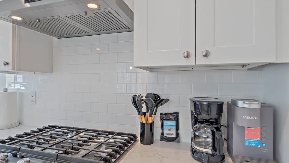 Enjoy your morning brew exactly how you like it with multiple coffee makers, including a Keurig and drip machine, right next to the high-end gas cooktop.
