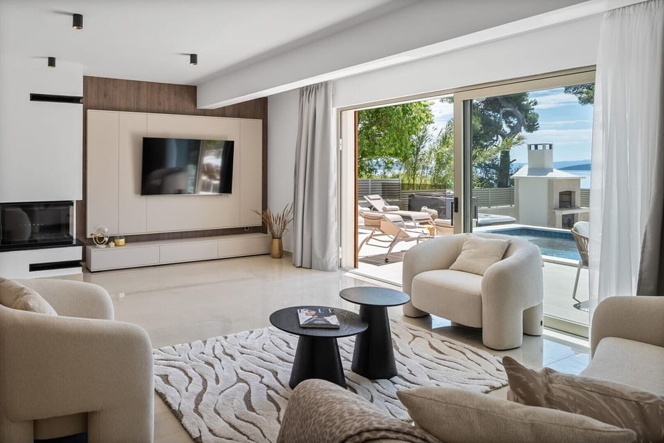 The living space is designed with large glass doors that flood the space with natural light and connect you to the pool and sea views
