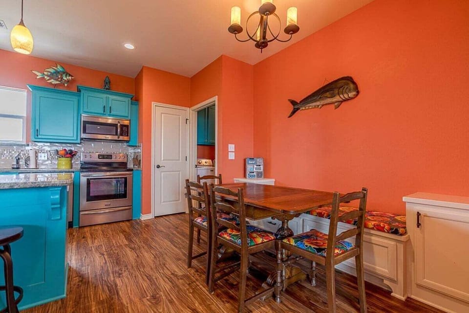 Dining area with wooden table seating, overhead lighting, and direct access to kitchen for easy entertaining.