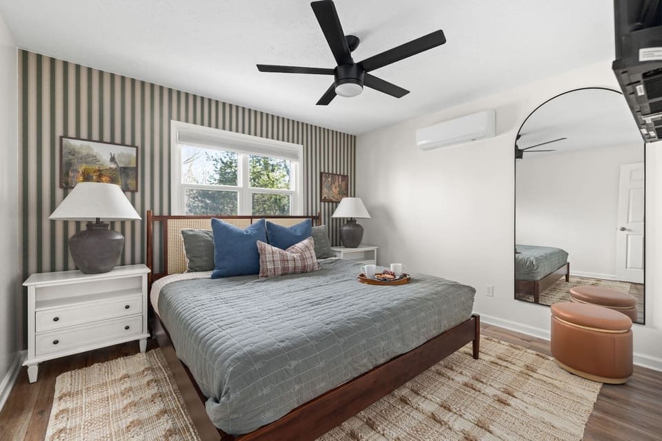 Main floor master is equipped with a king bed, two end tables and a full length mirror. 