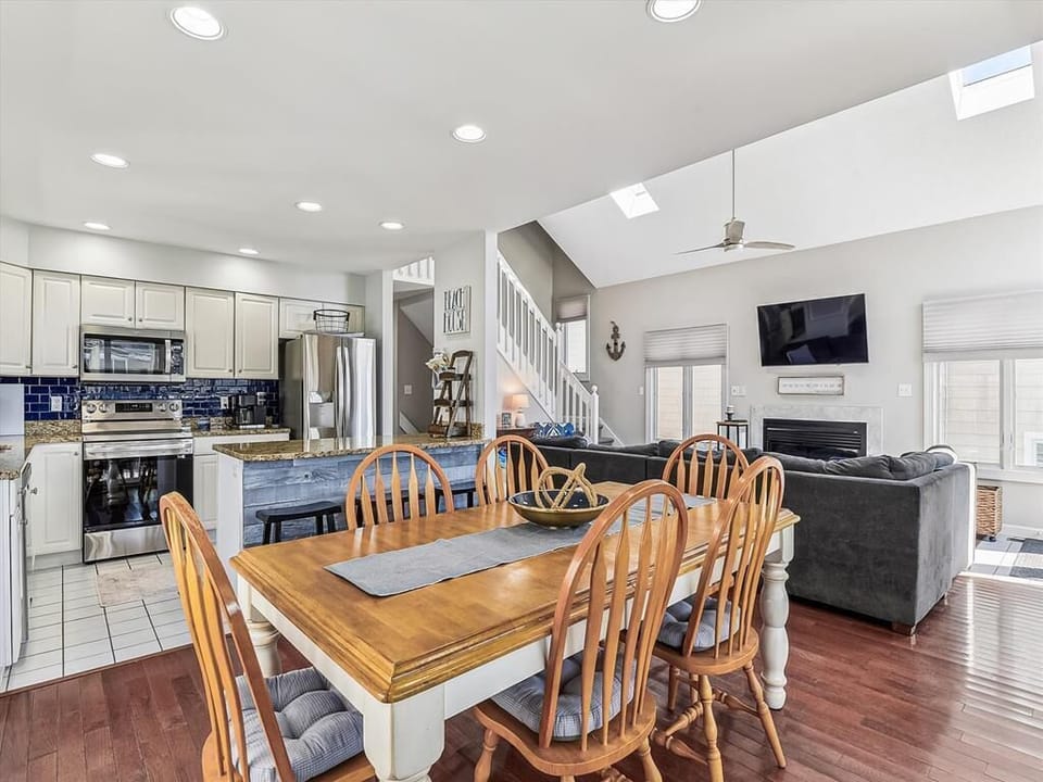 Spacious dining area with a large wooden table, perfect for gathering with family and friends for meals and game nights.
