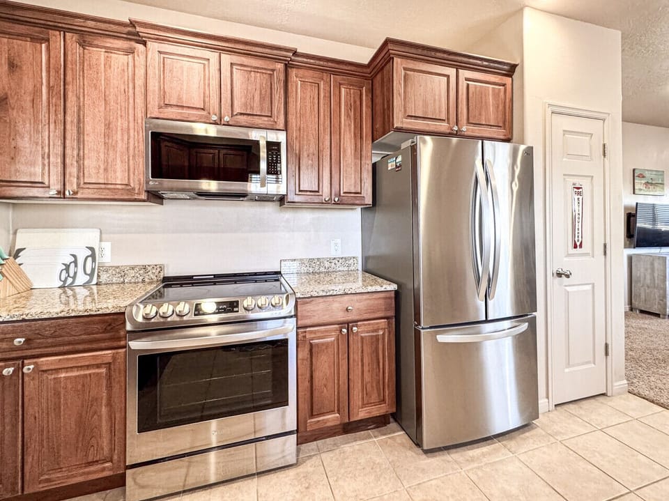 Sleek stainless steel appliances meet dark wood cabinetry in this bright, modern kitchen setup.