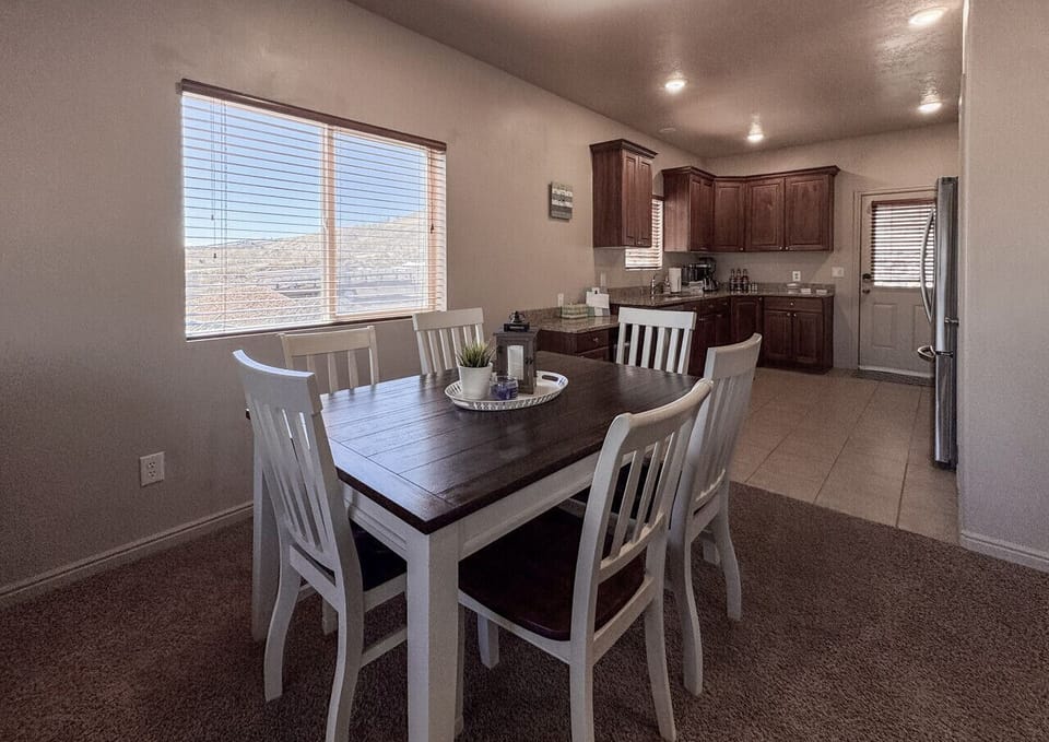 Charming dining area with natural light and a fully stocked kitchen—perfect for home-cooked meals.