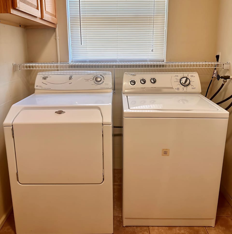 Enjoy the convenience of an in-home laundry room with a full-size washer and dryer, overhead shelving, and natural light — perfect for extended stays or refreshing your beachwear!