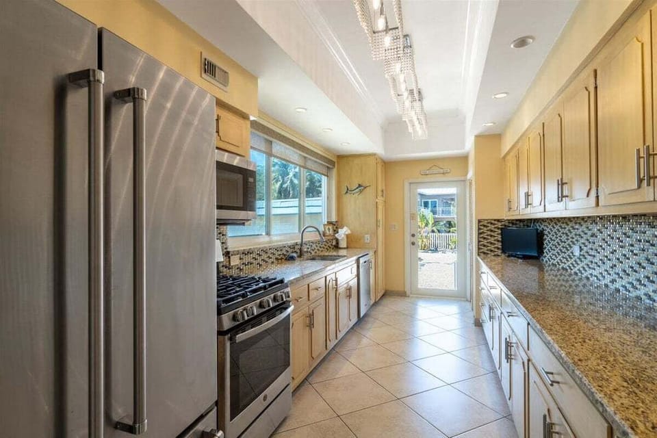 Fully equipped kitchen with modern appliances, pantry space, and easy access to indoor and outdoor living in a Marathon FL waterfront home.