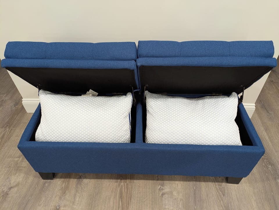 Extra pillows inside the blue ottoman. 