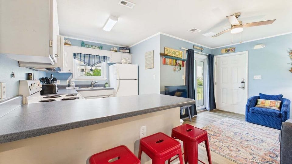 Open concept living area and full kitchen with breakfast bar and dining table