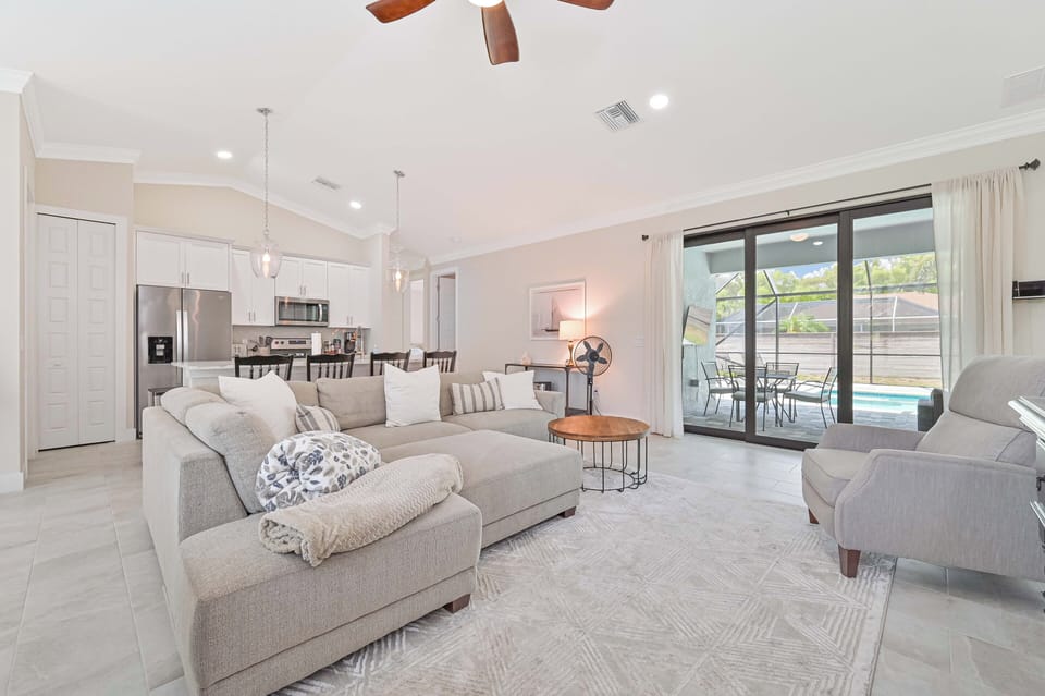 Coconut Point Oasis - Family room with large smart TV and sliding doors opening up to the screened in pool area