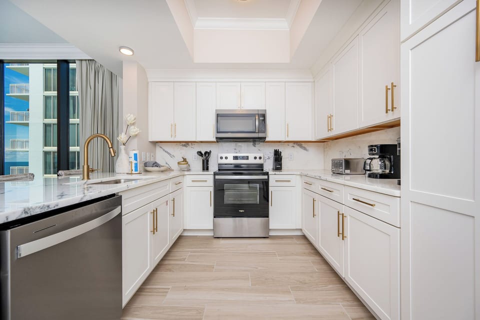 Prepare meals in this elegant kitchen featuring sleek countertops, stainless appliances, and stylish cabinetry