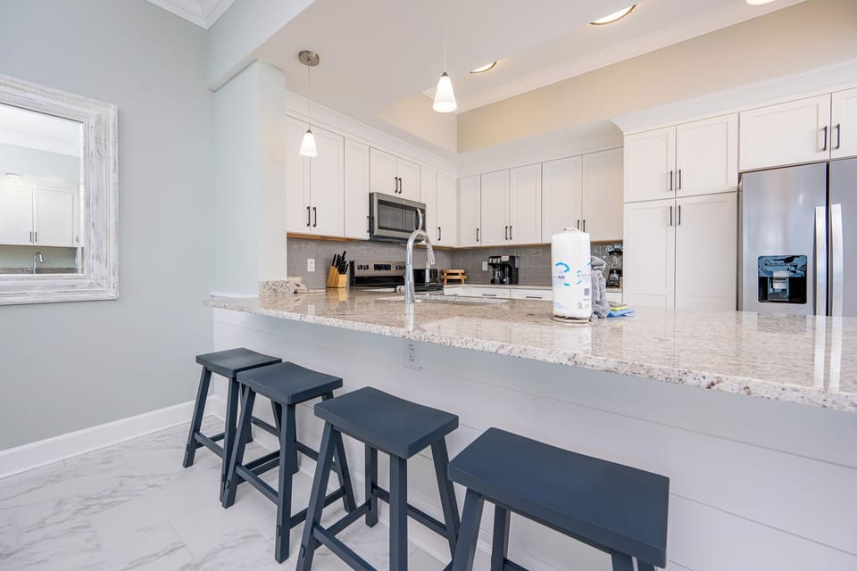Savor your morning coffee at the breakfast bar with stylish stools in this stylish kitchen