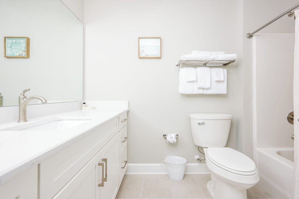 Refresh in this guest bathroom featuring a sleek vanity, plush towels, and tub-shower combo