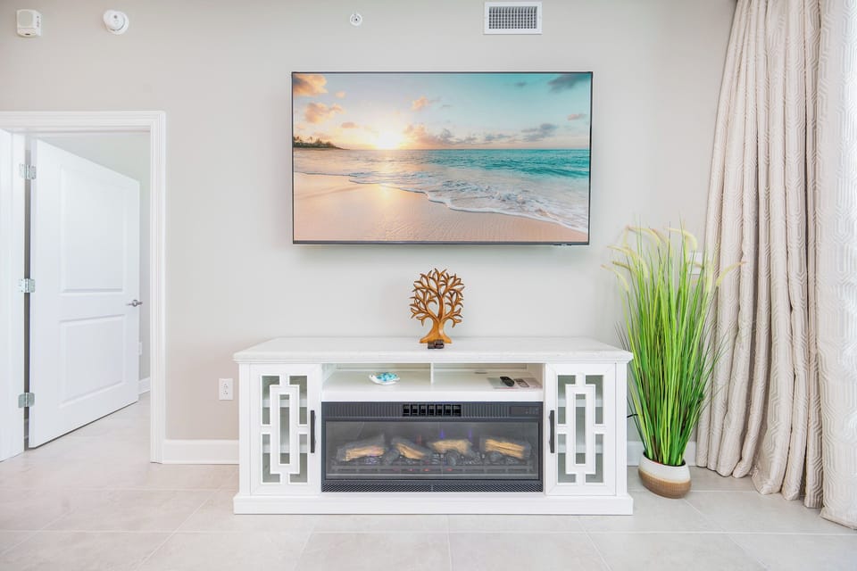 Enjoy the cozy ambiance created by the decor and stylish TV stand with a fireplace, perfect for relaxing evenings